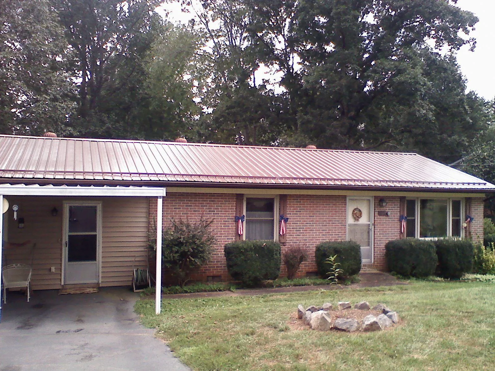 Bronze metal roof and carport on a brick ranch home — Roof Repair work by our crew in Meridian