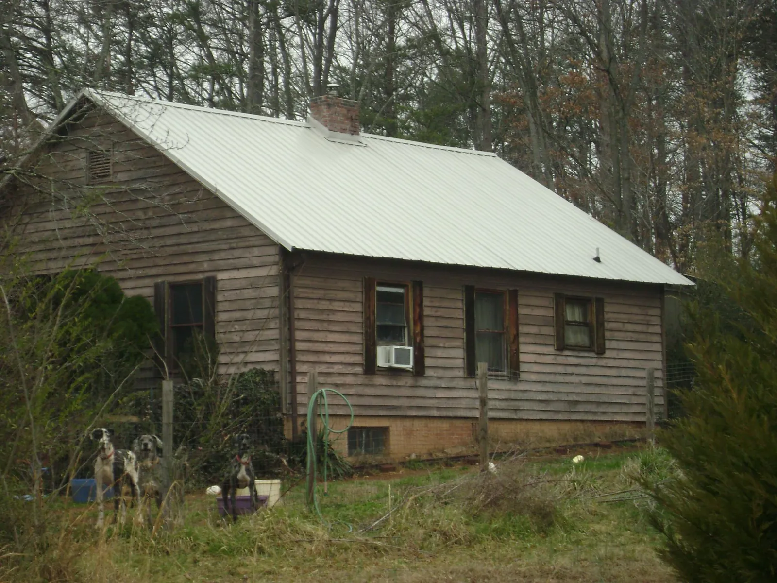 White metal roof on an old wood sided farmhouse, from a Metal Roof Installation job in Meridian